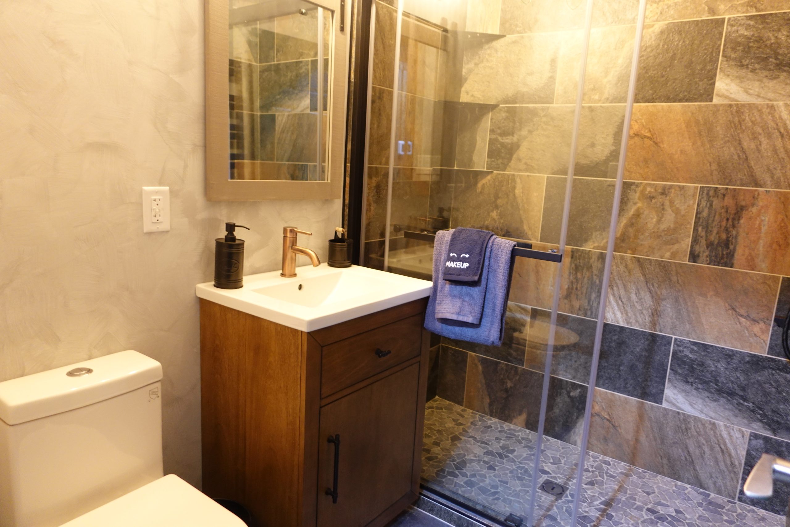 the second full bathroom, featuring a vanity, a lit walk in shower and a smart toilet