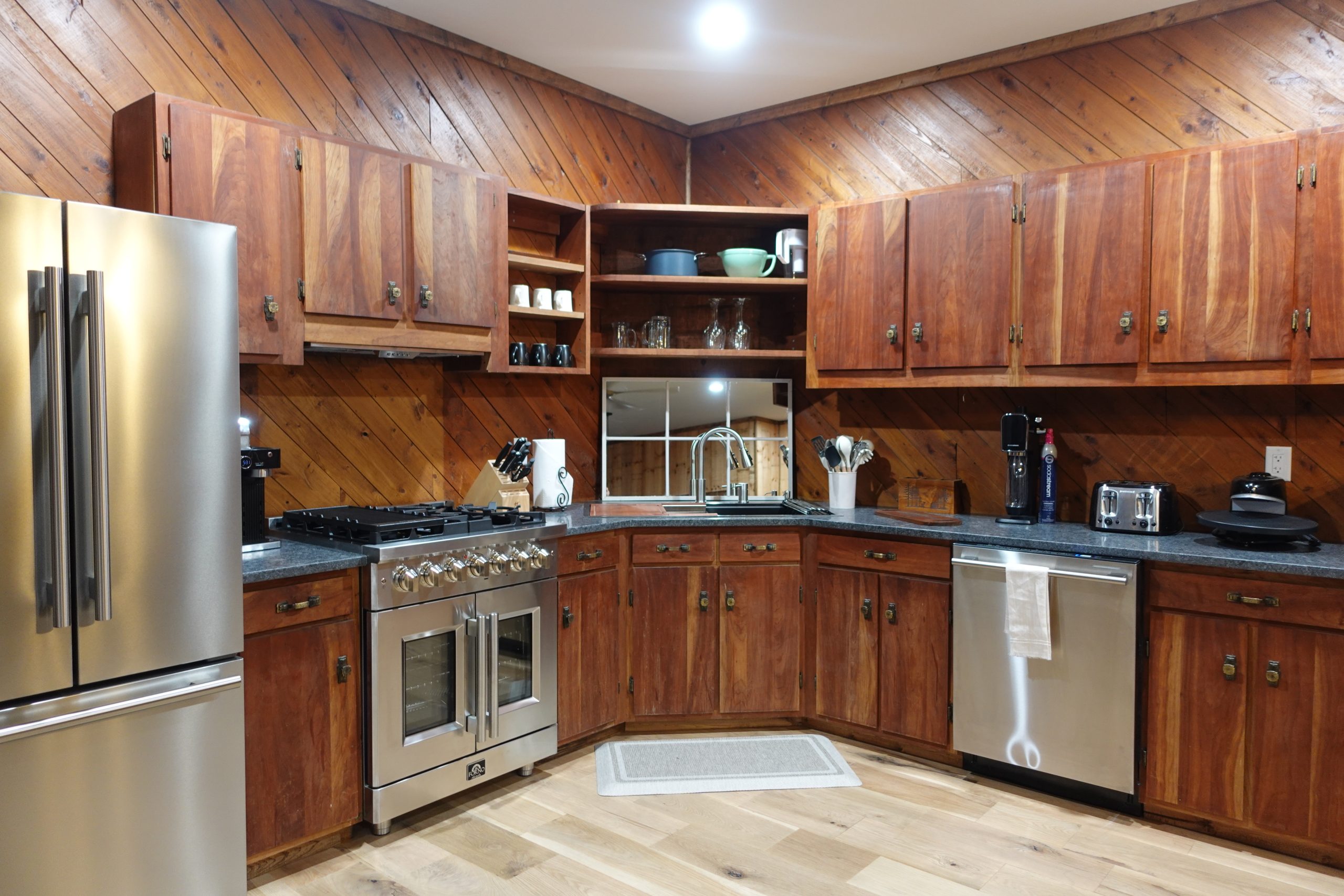 kitchen with all stainless steel, natural gas appliances including a full fridge, oven and stove with high temperature control, a double wide sink, and dishwasher with cabinets filled with kitchen ware and appliances.